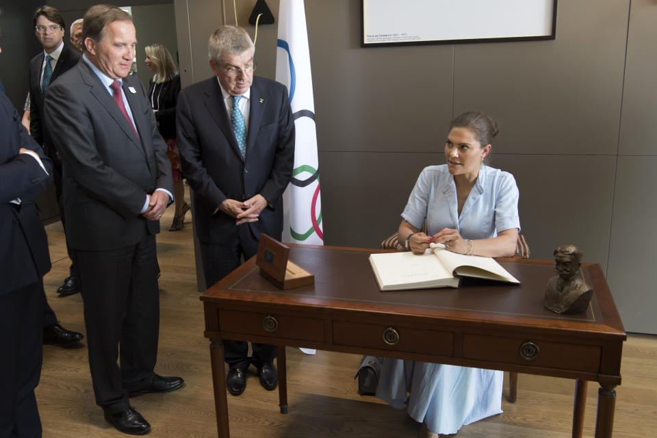 Sweden's Crown Princess Victoria, right, signs the guest book as International Olympic Committee (IOC) president Thomas Bach from Germany, center, and Swedish Prime Minister Stefan Lofven look on in Lausanne, Switzerland, Sunday, June 23, 2019. The host city of the 2026 Olympic Winter Games will be decided in Lausanne on Monday. (Laurent Gillieron/Keystone via AP))