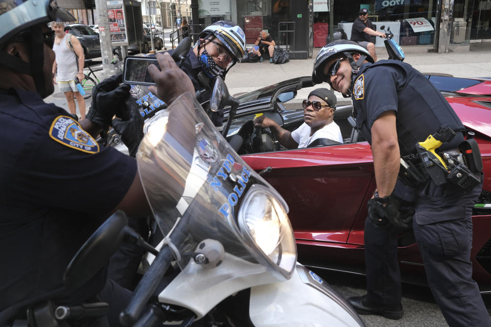 Comedian Tracy Morgan, second from right, stops for a picture with police officers as they were monitoring a protest in New York, Sunday, June 7, 2020. New York City lifted the curfew spurred by protests against police brutality ahead of schedule Sunday after a peaceful night, free of the clashes or ransacking of stores that rocked the city days earlier. (AP Photo/Seth Wenig)