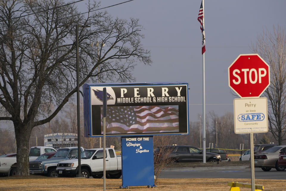 Vehicles sit parked in a lot outside of Perry High School following a shooting Thursday at the school, Friday, Jan. 5, 2024, in Perry, Iowa. (AP Photo/Charlie Neibergall)