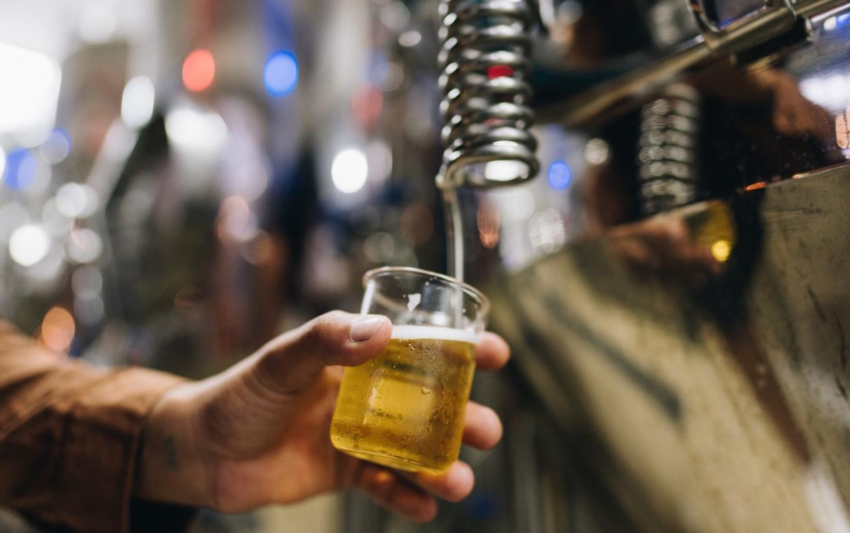 A glass of beer being poured in a brewery