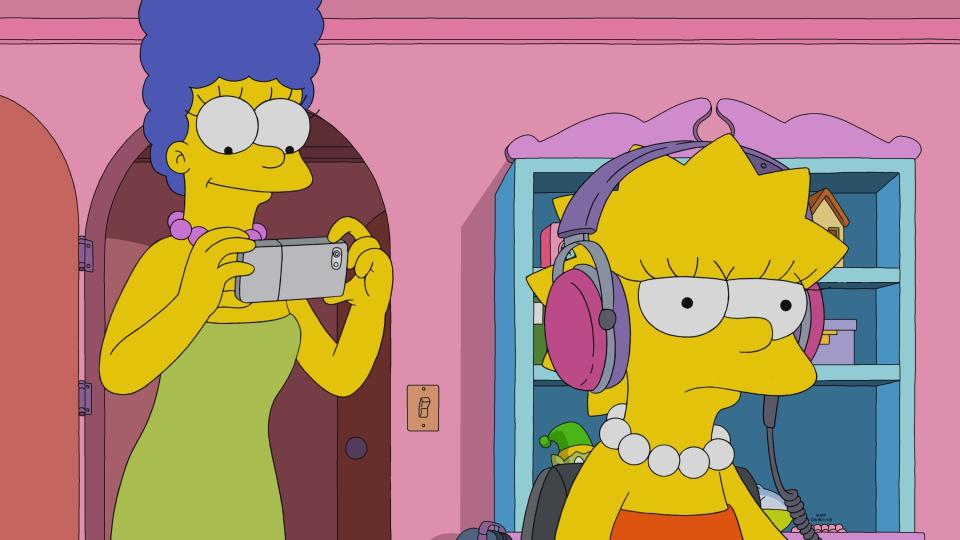 Marge Simpson taking a picture of Lisa, who has her back turned to her and her headphones on