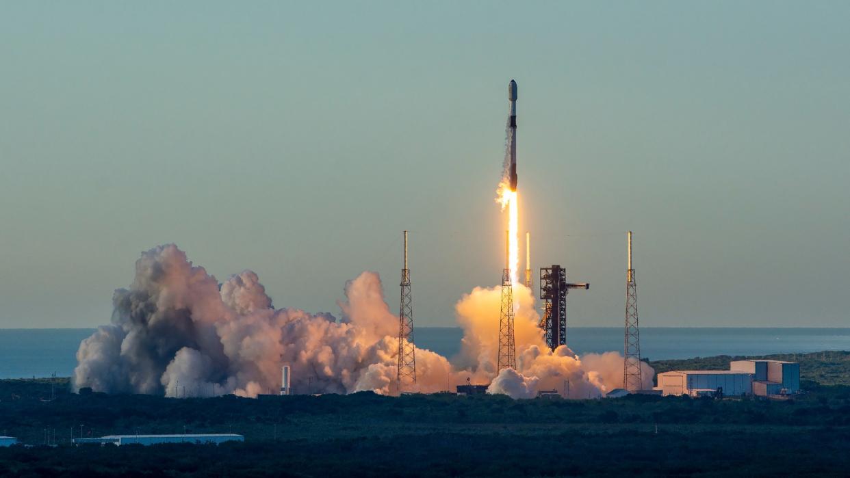  A rocket launches above a cloud of smoke and fire. 