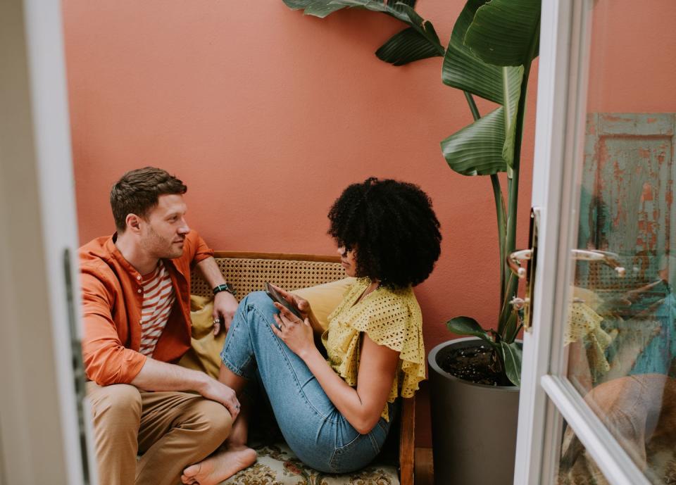 a couple have a serious talk on a rattan chair