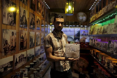 A shopkeeper holds a souvenir depicting the Dome of the Rock, located on the compound known to Muslims as Noble Sanctuary and to Jews as Temple Mount in Jerusalem's Old City May 27, 2015. REUTERS/Ammar Awad