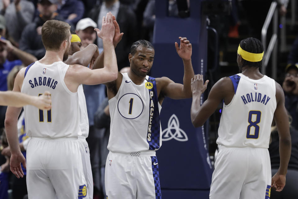 Indiana Pacers' T.J. Warren (1) is congratulated on blocking the shot of Philadelphia 76ers' Tobias Harris by Domantas Sabonis (11) and dJustin Holiday (8) during the second half of an NBA basketball game, Monday, Jan. 13, 2020, in Indianapolis. Indiana won 101-95. (AP Photo/Darron Cummings)