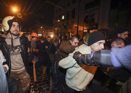 Interior Ministry members in plain-clothes who were detained by anti-government protesters during clashes, are escorted out after they were granted freedom in central Kiev February 21, 2014. REUTERS/Olga Yakimovich