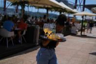 A waitress removes drinks from a table in a restaurant in Lisbon