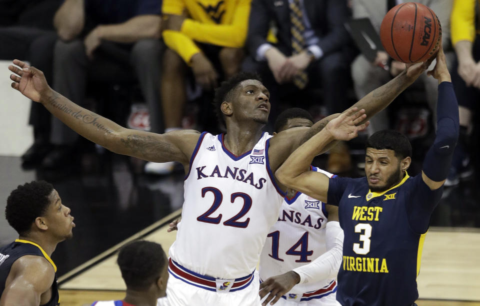 FILE - In this March 10, 2018, file photo, Kansas forward Silvio De Sousa (22) tips the ball away from West Virginia guard James Bolden (3) during the second half of an NCAA college basketball game in the finals of the Big 12 men's tournament, in Kansas City, Mo. Kansas forward Silvio De Sousa, whose name surfaced as part of the FBI’s investigation into corruption in college basketball, will be withheld from competition pending a review of his eligibility. Jayhawks coach Bill Self said in a statement before appearing at the Big 12’s annual media day Wednesday, Oct. 24,2018, that the sophomore forward would be held out beginning with Thursday’s exhibition game. (AP Photo/Orlin Wagner, File)