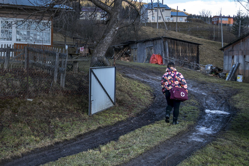 Dr. Viktoria Mahnych, walks on country road to attend to her patient near Iltsi village, Ivano-Frankivsk region of Western Ukraine, Wednesday, Jan. 6, 2021. Ukraine is struggling to contain the coronavirus pandemic that has inundated its overburdened medical system, as Dr. Viktoria Mahnych goes door to door providing much needed help to patients. (AP Photo/Evgeniy Maloletka)