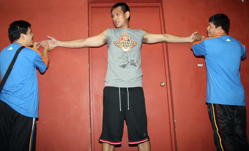 Officials measure Junmar Fajardo's wingspan. (PBA Images)