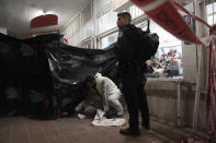 A member of Israeli Zaka Rescue and Recovery team cleans blood and human remains from the site where a gunman opened fire in Bnei Brak, Israel, Tuesday, March 29, 2022. A gunman on a motorcycle opened fire in central Israel late Tuesday, in the second fatal mass shooting rampage this week. The shooter was killed by police. (AP PhotoOded Balilty)