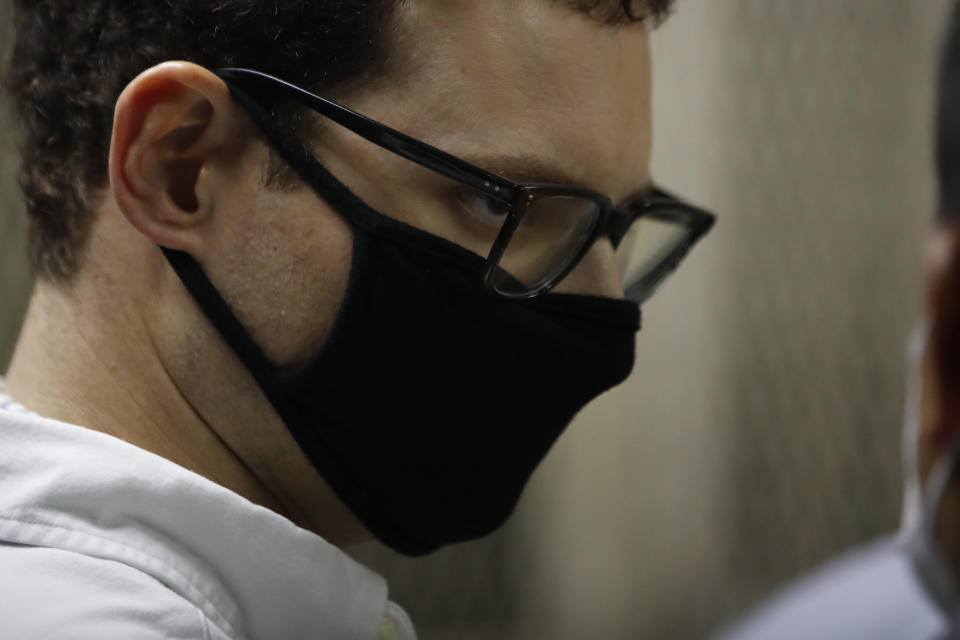 Luis Enrique Martinelli Linares, son of former Panamanian President Ricardo Martinelli, listens to his lawyers before a hearing at the judicial court building in Guatemala City, Monday, July 6, 2020. Guatemalan police detained the Martinelli brothers, Luis Enrique and Ricardo, on an Interpol warrant for money laundering, as they attempted to board a private plane out of the country. (AP Photo/Moises Castillo)