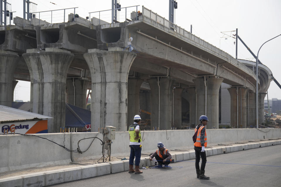 FILE - Workers use a measuring line at the construction site of Halim Station ahead of an operational test run of the Jakarta-Bandung high-speed train in September, in Jakarta, Indonesia, on Aug. 12, 2023. Indonesian President Joko Widodo's phenomenal rise from a riverside slum, where he grew up, to the presidency of Indonesia spotlighted how far the world's third-largest democracy had veered from a brutal authoritarian era a decade ago. With his second and final five-year term ending in October, Widodo, regarded by some as Asia's Barack Obama, is leaving a legacy of impressive economic growth and an ambitious array of infrastructure projects including a $33 billion plan to relocate Indonesia's congested capital to the frontier island of Borneo. (AP Photo/Dita Alangkara, File)