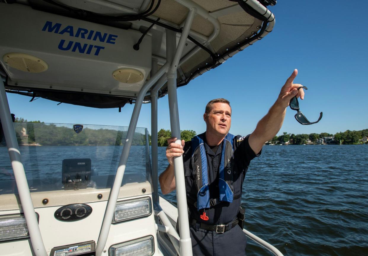 Shrewsbury Police Officer Shaun Valliere points from his patrol boat to where bald eagles are nesting on a Lake Quinsigamond island Thursday.