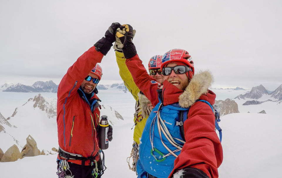 Friends Leo Houlding (right), Jean Burgun (centre) and Mark Sedon celebrate making it to the top of the Sceptre. (SWNS)