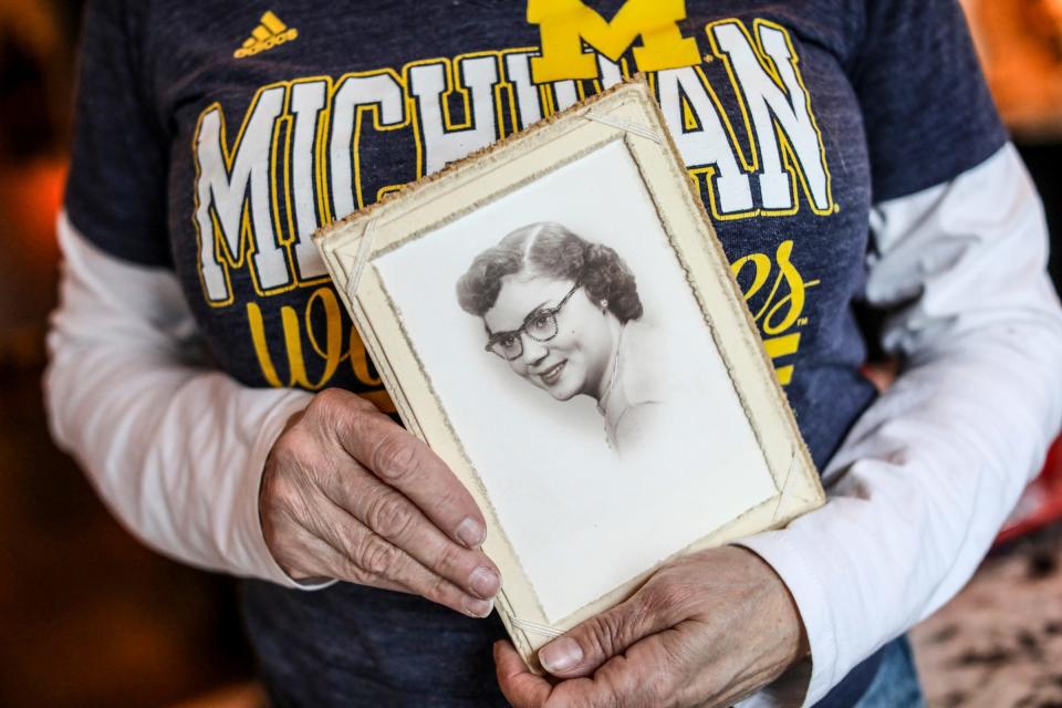 Diane Miller, 63, of Wyandotte, holds a high school graduation photo of her mother, Winnie Burke, who she says was the biggest fan in the room. Miller wears the same thing for every University of Michigan football game for good luck.