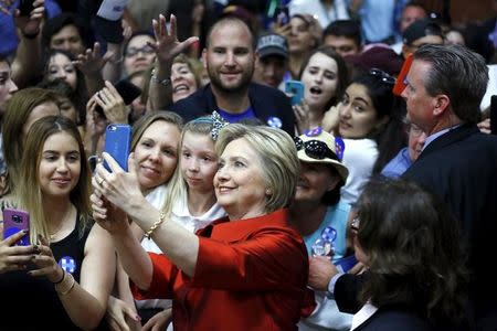 Democratic U.S. presidential candidate Hillary Clinton takes a selfie with supporters at a campaign rally at Carl Hayden Community High School in Phoenix, Arizona March 21, 2016. REUTERS/Mario Anzuoni