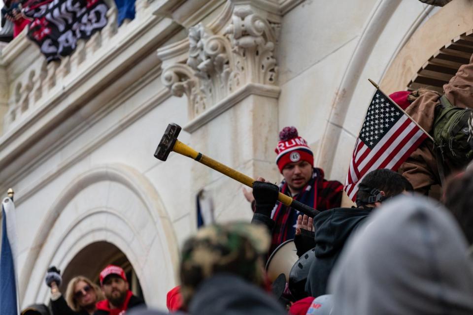 PHOTO: Demonstrators pass a sledgehammer forward to help in their attempt to enter the U.S. Capitol building during the protests in Washington, D.C., Jan. 6, 2021.  (Eric Lee/Bloomberg via Getty Images)