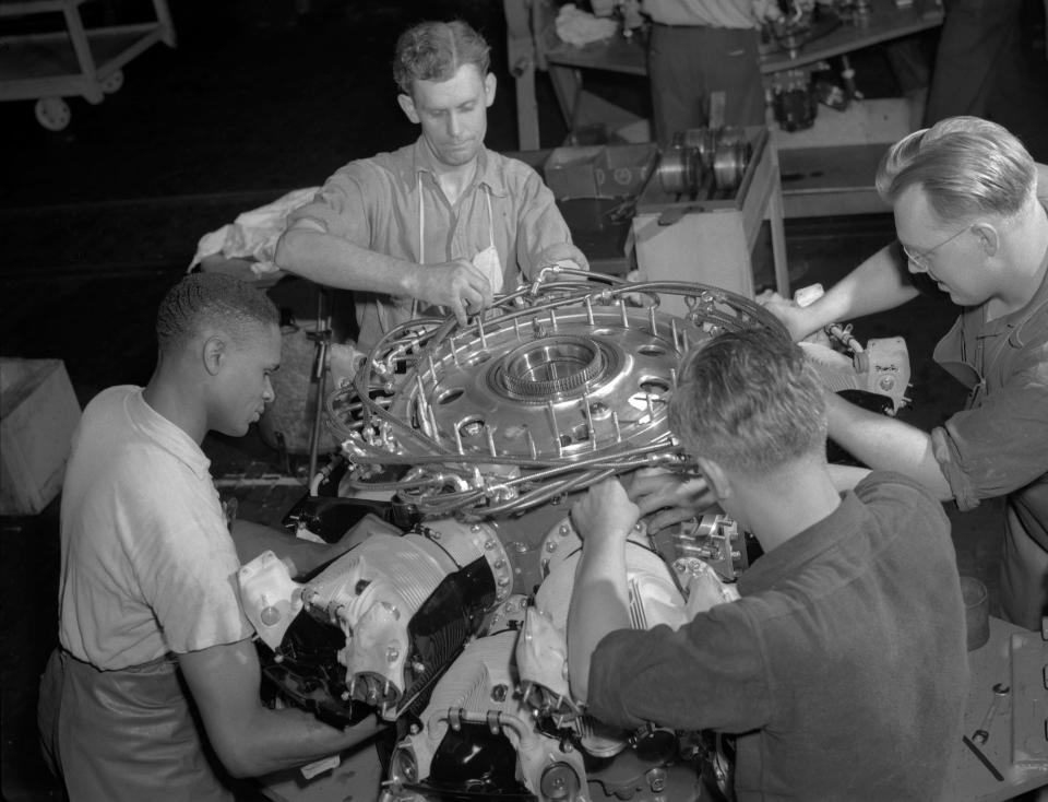 Men working on engine at factory during World War II