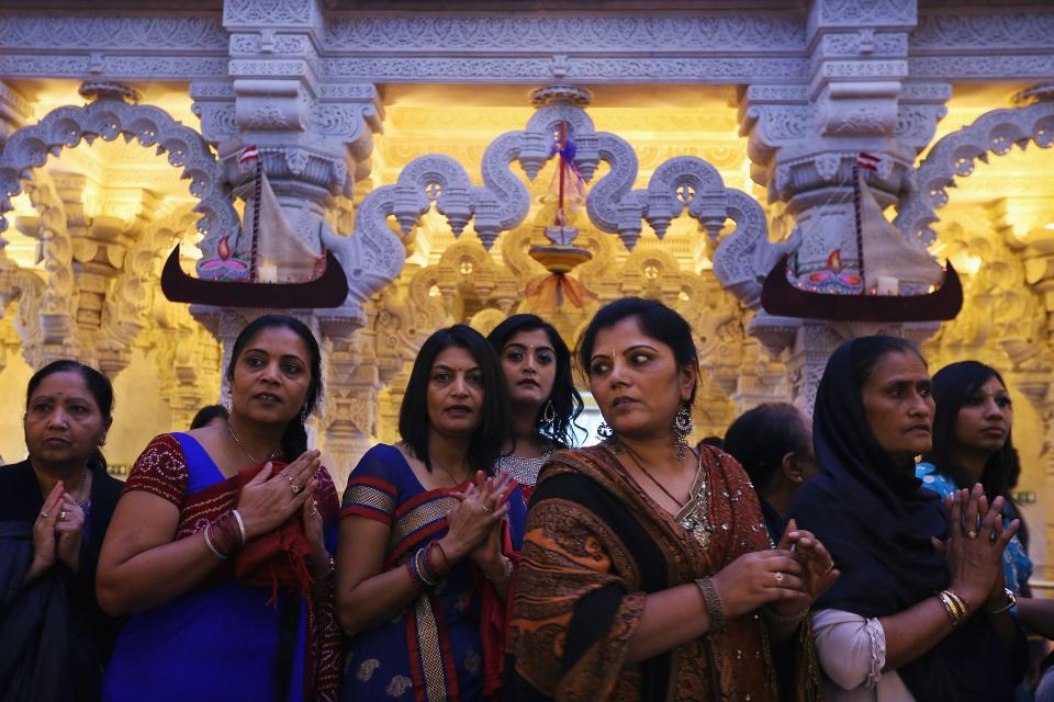 LONDON, ENGLAND - NOVEMBER 14: Women prey in a shrine as Sadhus and Hindus celebrate Diwali at the BAPS Shri Swaminarayan Mandir on November 14, 2011 in London, England. Diwali, which marks the start of the Hindu New Year, is being celebrated by thousands of Hindu men women and children in the Neasden mandir, which was the first traditional Hindu temple to open in Europe. (Photo by Dan Kitwood/Getty Images)