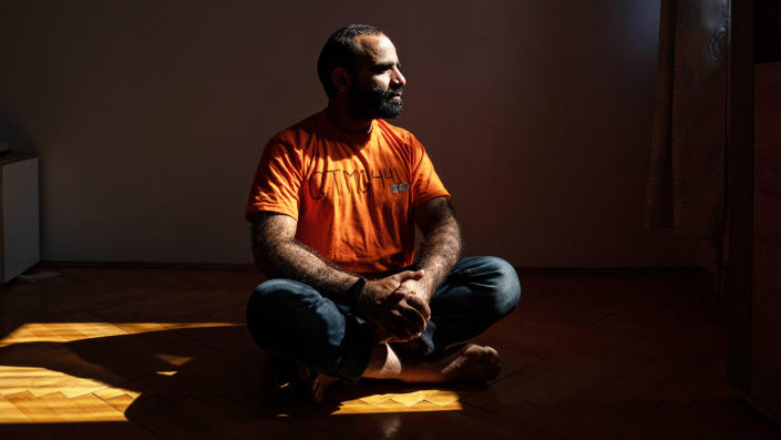 Mansoor Adayfi, former Guantanamo Bay detainee, sits on the floor.