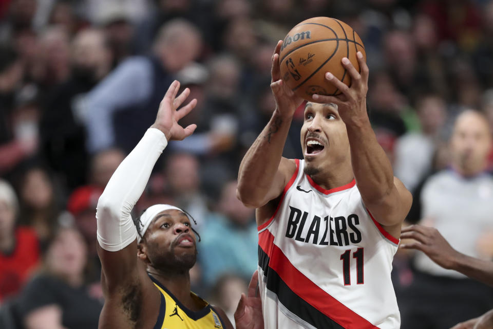 Portland Trail Blazers guard Malcolm Brogdon (11) drives to the basket as Indiana Pacers guard Buddy Hield (7) defends during the first half of an NBA basketball game Friday, Jan. 19, 2024, in Portland, Ore. (AP Photo/Amanda Loman)