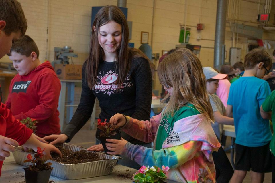 WB_Farm_Field_Trip_6.jpg - High School students in West Branch’s agriculture classes guided younger students in planting a flower to take home.