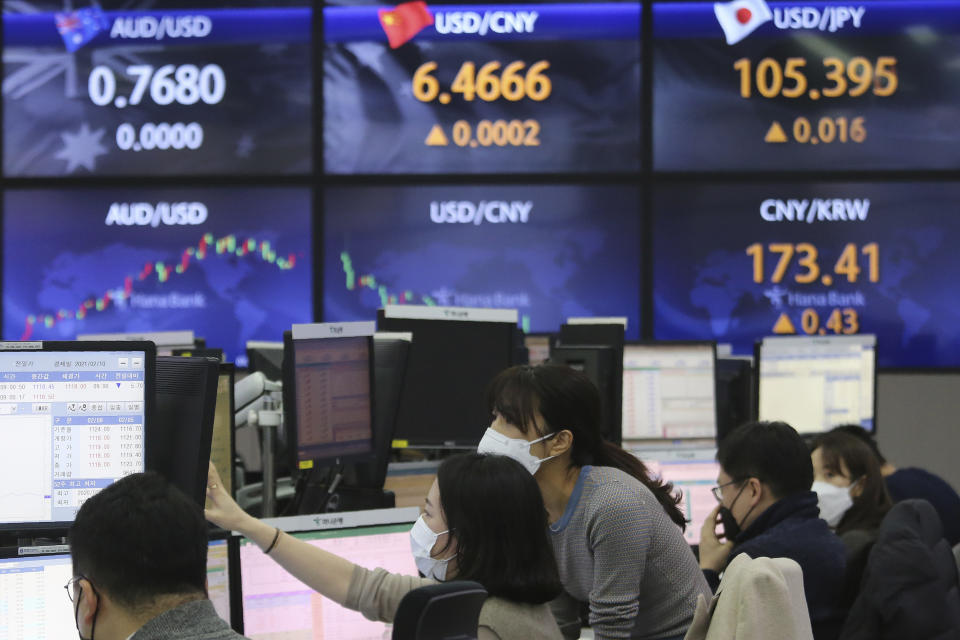 Currency traders watch monitors at the foreign exchange dealing room of the KEB Hana Bank headquarters in Seoul, South Korea, Monday, Feb. 8, 2021. Asian shares mostly rose Monday, tracking a rally on Wall Street last week, with Japan's benchmark momentarily reaching three-decade highs, on growing optimism about the global economy. (AP Photo/Ahn Young-joon)