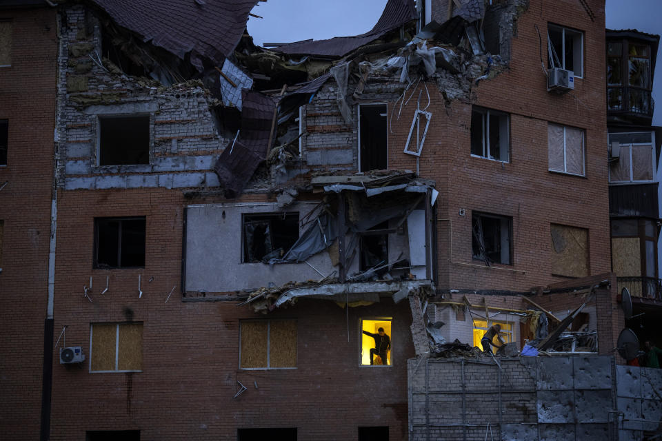 People check the damage at their apartments hit by a Russian missile in Mykolaiv, Sunday, Oct. 23, 2022. (AP Photo/Emilio Morenatti)