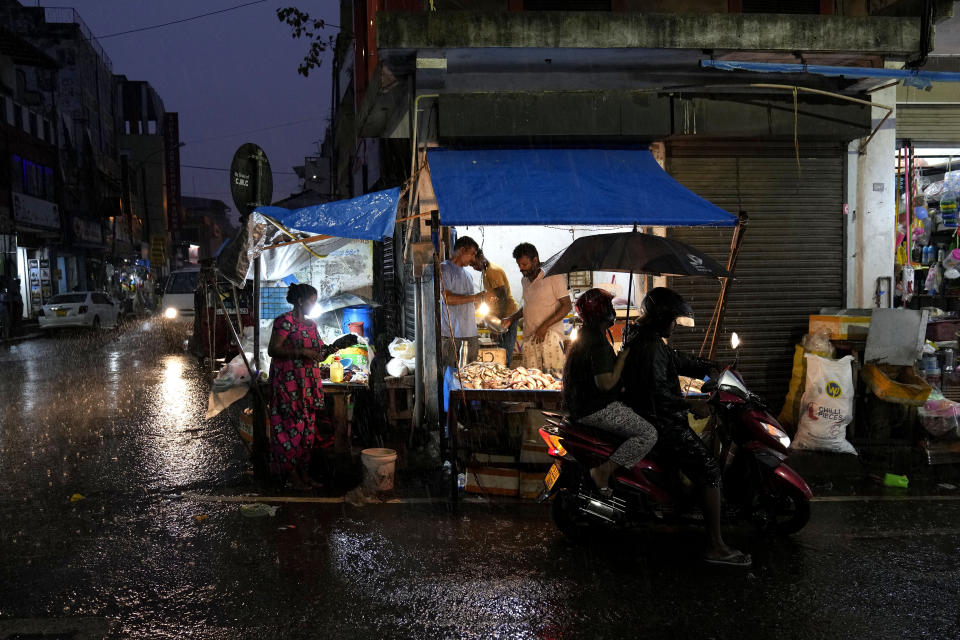 Roadside vendors wait for customers at a market place in Colombo, Sri Lanka, Friday, Dec. 8, 2023. The Asian Development Bank said Friday that it has approved $200-million concessional loan to debt-stricken Sri Lanka to help stabilize the country's finance sector following an unprecedented economic crisis that engulfed the Indian Ocean island nation last year. (AP Photo/Eranga Jayawardena)