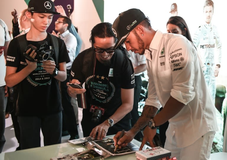 Mercedes AMG Petronas F1 Team's British driver Lewis Hamilton signs autographs during a 'meet the fans' session in Kuala Lumpur, on September 27, 2016, ahead of the Malaysian Grand Prix