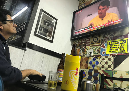 A man watches an interview on television with presidential candidate Jair Bolsonaro at a bar in Sao Paulo, Brazil September 28, 2018. REUTERS/Nacho Doce