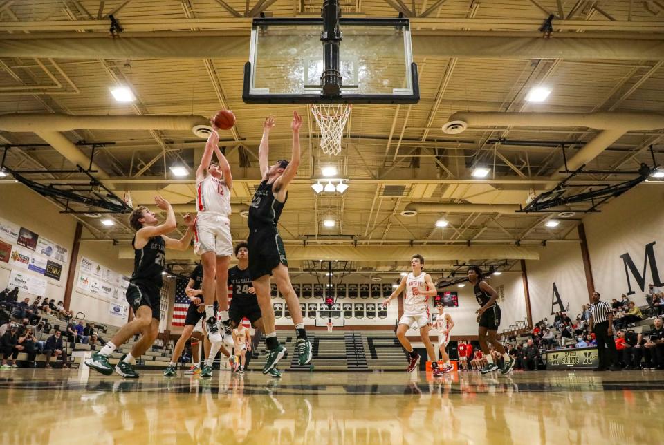 Mater Dei's Zack Davidson (12) jumps for a shot as De La Salle's Johnny Semany (20, left) and John Flannigan (32, right) try to block during the second period of their game at Xavier Prep High School, Thursday, Dec. 30, 2021, in Palm Desert, Calif. 