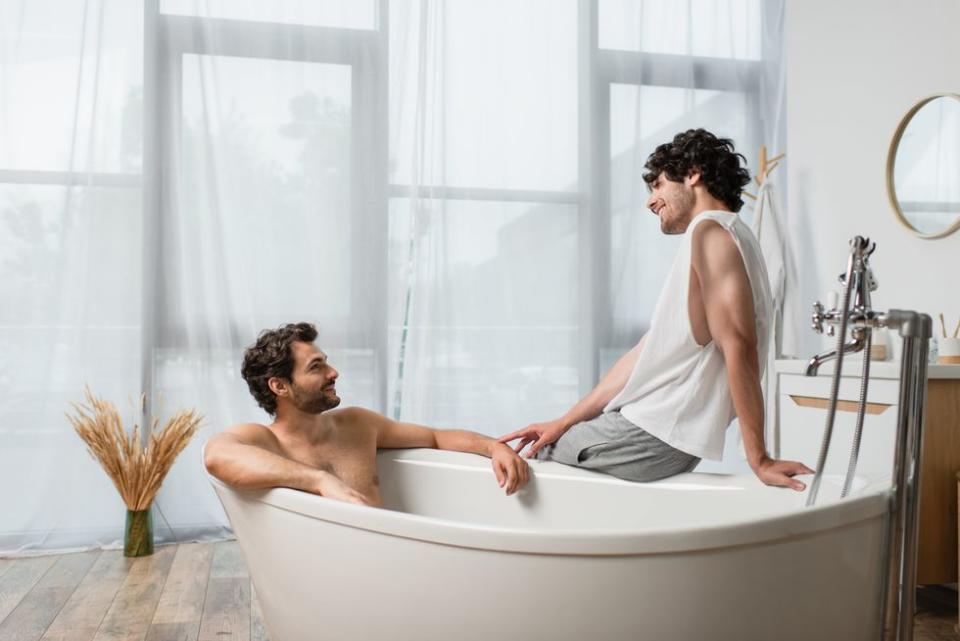 two men in and on a bathtub