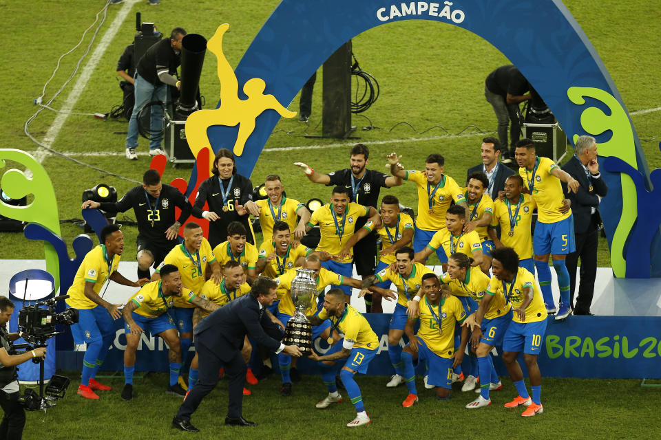 Brazil's Dani Alves celebrates with the trophy and his teammates after Copa America final win over Peru