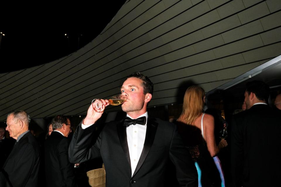 A man drinks champagne.