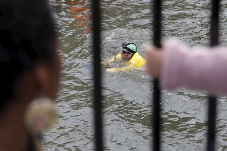 Christopher Swain, a clean-water activist, swims in the Gowanus Canal in the Brooklyn borough of New York April 22, 2015. REUTERS/Shannon Stapleton