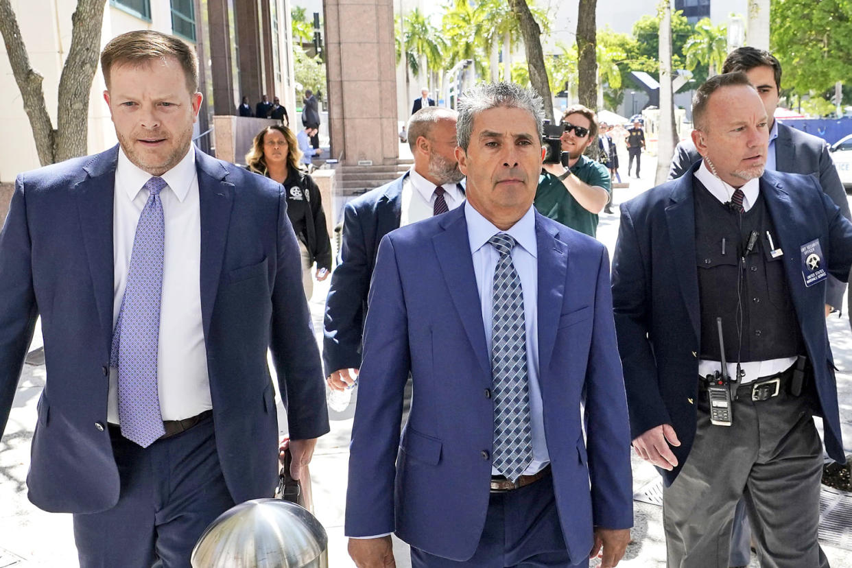 Carlos De Oliveira, center, an employee of Donald Trump's Mar-a-Lago estate, leaves a court appearance with attorney John Irving, left, at the James Lawrence King Federal Justice Building, Monday, July 31, 2023, in Miami. De Oliveira, Mar-a-Lago's property manager, was added last week to the indictment with Trump and the former president's valet, Walt Nauta, in the federal case alleging a plot to illegally keep top-secret records at Trump's Florida estate and thwart government efforts to retrieve them. (Wilfredo Lee / AP file)