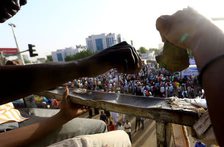 Sudanese demonstrators use stones to make a rhythm during the sit-in protest outside Defence Ministry in Khartoum, Sudan April 20, 2019. REUTERS/Mohamed Nureldin Abdallah