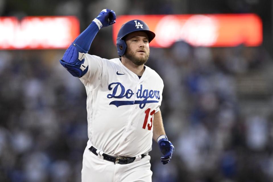 Max Muncy raises a fist as he runs.