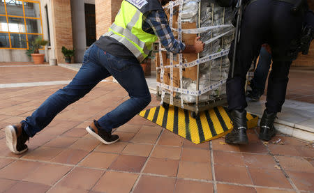 Police push a cart with a portion of the six tonnes of cocaine seized at an industrial estate prior to a press display of confiscated drugs and other material siezed in the operation at the police headquarters in Malaga, Spain, October 25, 2018. REUTERS/Jon Nazca