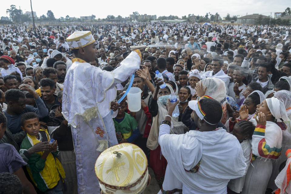 Ethiopian Orthodox Christians are sprayed with water in a ceremony to celebrate the second day of the festival of Timkat, or Epiphany, in the capital Addis Ababa, Ethiopia Wednesday, Jan. 19, 2022. The annual festival celebrates the baptism of Jesus Christ in the River Jordan. (AP Photo)