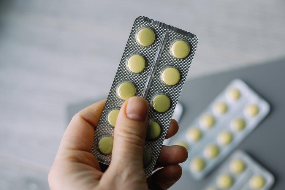 person holding a blister pack of pills