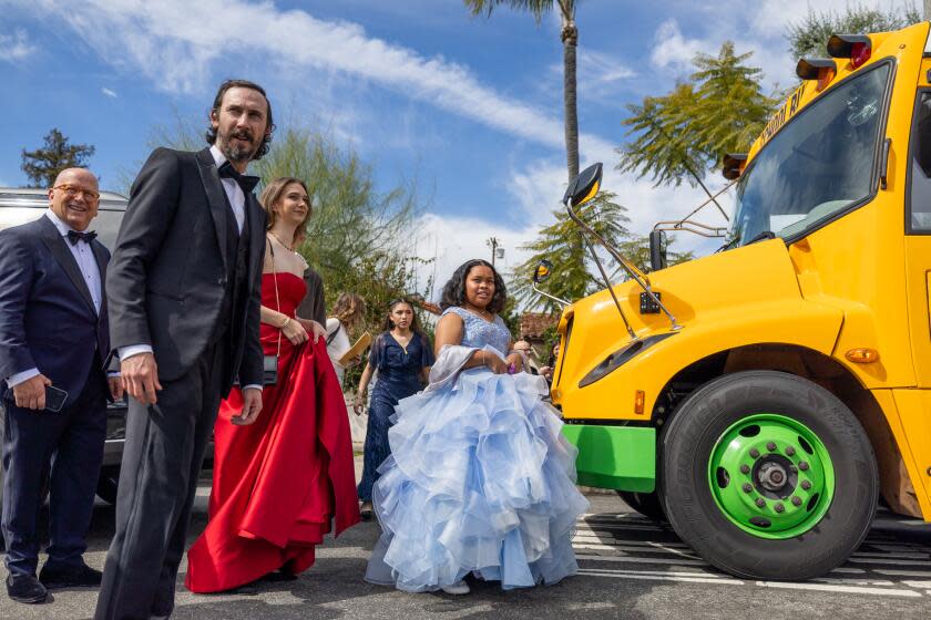 North Hollywood, CA - March 10: Film participant and Palms Middle School sixth-grader Porche Brinker, center, joins film makers and fellow participants as they board a LAUSD school bus to ride to the Oscars Sunday, March 10,2024. The students and instrument repair technicians are featured in the "Last Repair Shop" and get ready to attend the Oscars, where the film is nominated for Best Documentary Short Film. (Allen J. Schaben / Los Angeles Times)