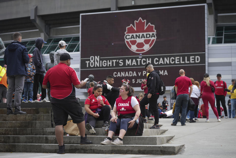 Fans sit and gather outside B.C. Place stadium after the Canadian national men's soccer team's friendly match against Panama was canceled due to a labor dispute, in Vancouver, British Columbia, Sunday, June 5, 2022. (Darryl Dyck/The Canadian Press via AP)