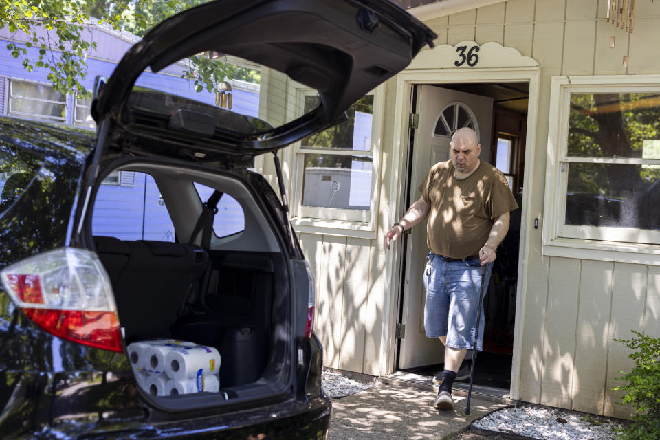 Jeremy Ward unloads groceries from his car to his home in the Ridgeview Homes mobile home community in in Lockport, N.Y., June 23, 2022. Ward is one of the residents at Ridgeview participating in a rent strike after new owners of the park announced they were raising rents by six percent. "I moved here because it's basically the most affordable living," said Ward, who is disabled and living off of a fixed income. The plight of residents at Ridgeview is playing out nationwide as institutional investors, led by private equity firms and real estate trusts and sometimes funded by pension funds, swoop in to buy mobile home parks. (AP Photo/Lauren Petracca)