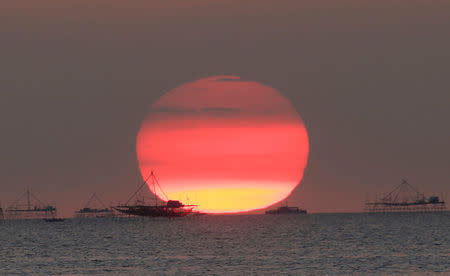 FILE PHOTO: Houses on stilts are seen as the sun sets around the Manila bay in Manila, Philippines February 5, 2015. REUTERS/Romeo Ranoco/File Photo