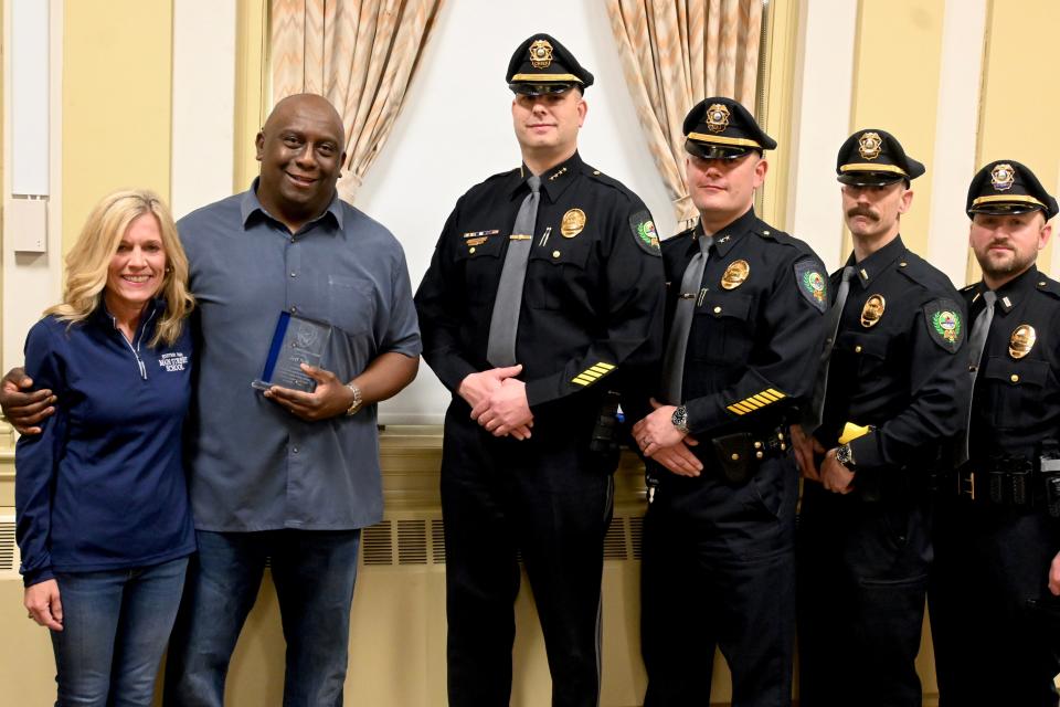 Exeter police, including Chief Stephan Poulin, center, honored resident Jeff Neil, at left with his wife, Libby, with a Citizen Award Friday, March 24, 2023, in recognition of his actions aboard a recent United Airlines flight.