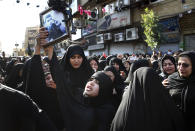 Families of victims of Saturday's terror attack on a military parade in the southwestern city of Ahvaz, that killed 25 people attend a mass funeral ceremony, in Ahvaz, Iran, Monday, Sept. 24, 2018. Thousands of mourners gathered at the Sarallah Mosque on Ahvaz's Taleghani junction, carrying caskets in the sweltering heat. (AP Photo/Ebrahim Noroozi)