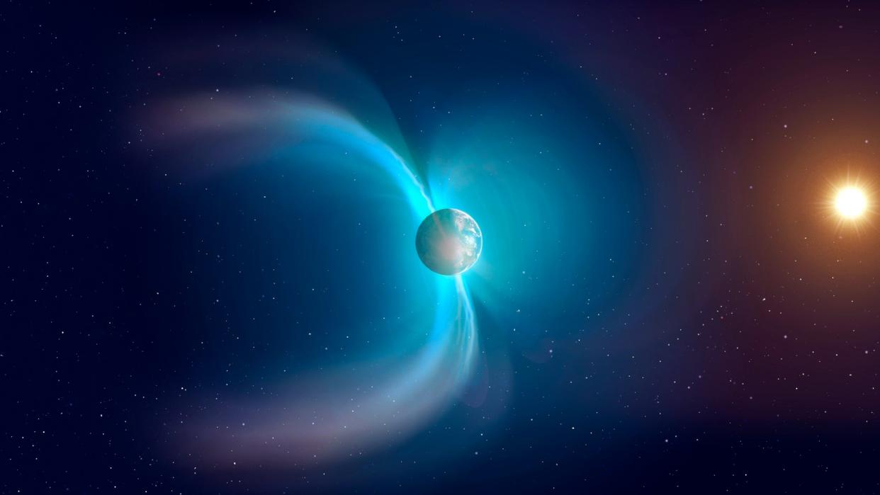  Earth in space with a two blue fields emanating from it indicating the planet's magnetic field. 